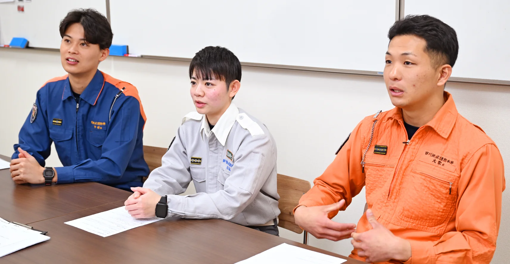 中村さん、松浪さん、大家さんが長机の前の椅子に座り、インタビューを受けている様子