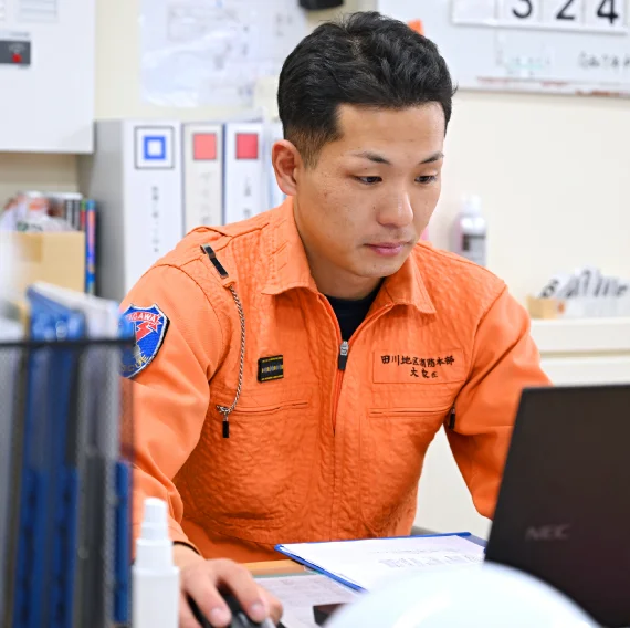 大家さんが机上のノートパソコンを使い、事務作業をしている様子